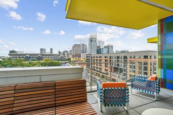 A rooftop terrace with chairs and a view of the city